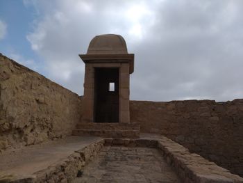 View of old building against cloudy sky
