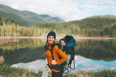 Woman standing by lake against plants