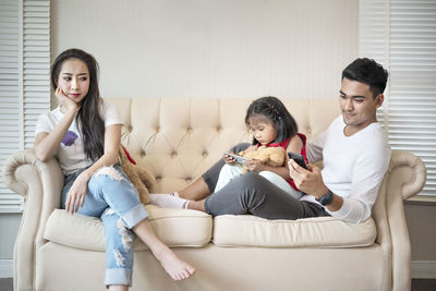 Happy friends sitting on sofa