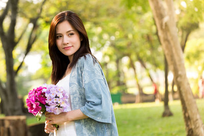 Portrait of smiling young woman against blue sky