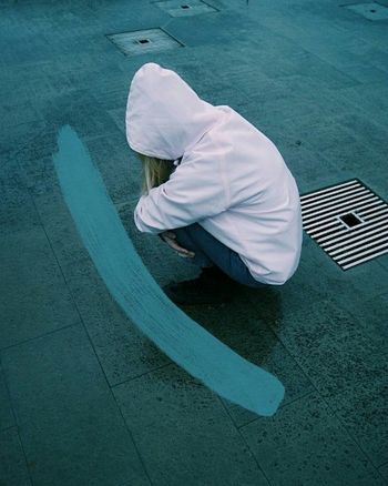 HIGH ANGLE VIEW OF A MAN SITTING ON FLOOR