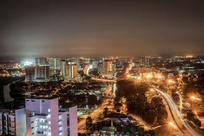 High angle view of illuminated buildings against sky at night