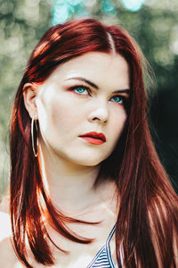 Close-up of thoughtful redhead woman looking up