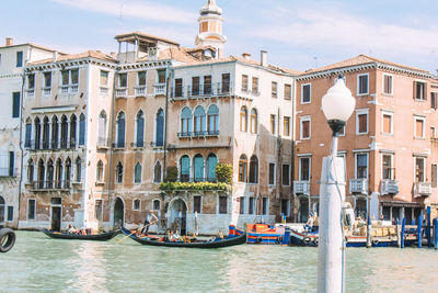 Gondolas moored in grand canal by buildings