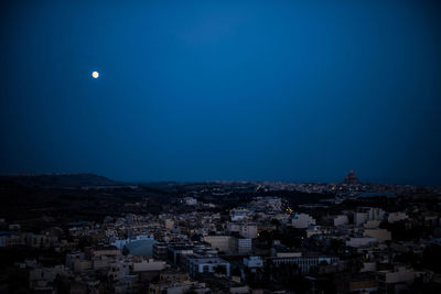 Illuminated city against sky at night