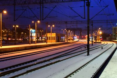 Illuminated railroad station platform in city at night