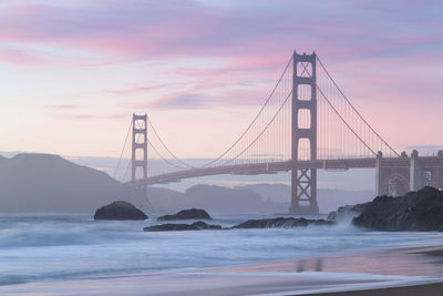 View of suspension bridge against cloudy sky