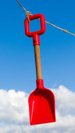 Low angle view of red hanging against sky