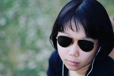 High angle view of teenage girl wearing sunglasses while listening music