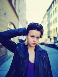 Portrait of woman standing against black background