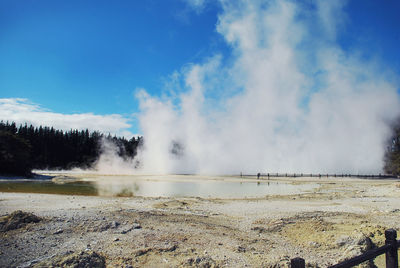 Smoke emitting from geyser against sky