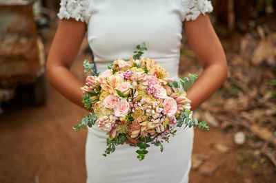 Midsection of woman holding flower bouquet