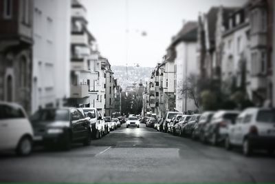 Cars on street in city against sky