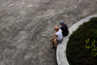 High angle view of couple sitting by road