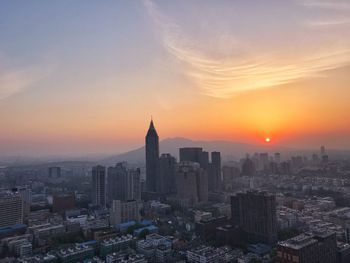 Modern buildings against sky during sunset