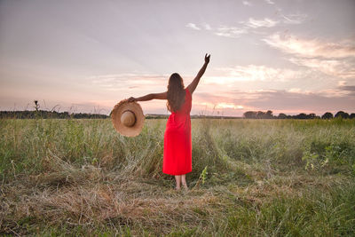 Rear view of woman standing on land against sky