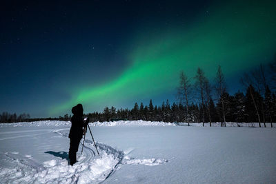 Rear view of man standing on snow