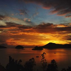 Scenic view of sea against dramatic sky during sunset