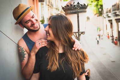 Happy young couple standing in balcony by street lamp