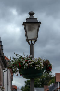 Low angle view of street light against cloudy sky