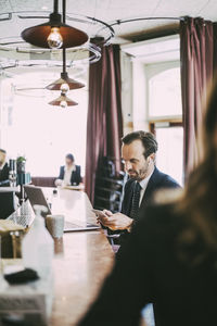 Male entrepreneur using phone in restaurant