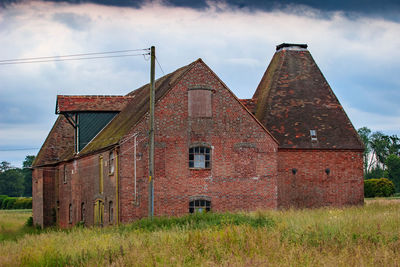 Old building on field against sky