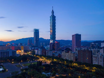 Illuminated buildings in city against sky