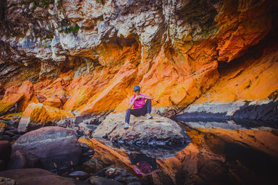 Rear view of woman walking on rock