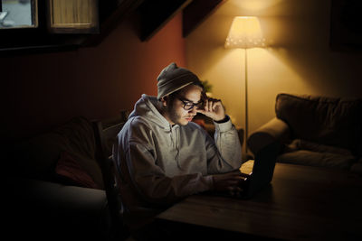 Full length of young man sitting at home