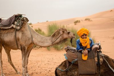Woman sitting on sand in desert