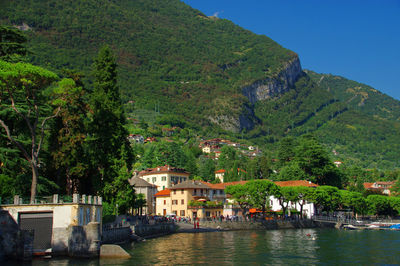 Lake with built structures against lush foliage