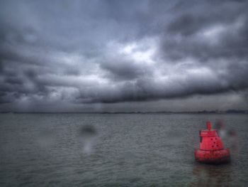 Scenic view of sea against cloudy sky