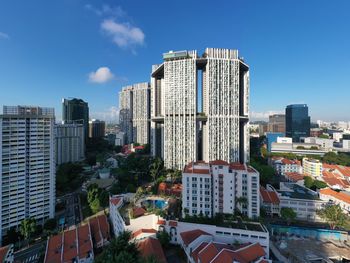 Buildings in city against blue sky