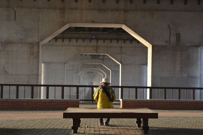 Rear view of man sitting on bench