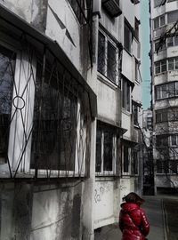 Rear view of woman in city against sky