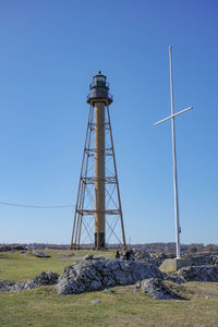 Low angle view of tower on field against clear blue sky