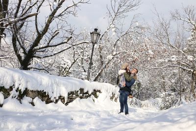 Full length of man standing on snow covered tree