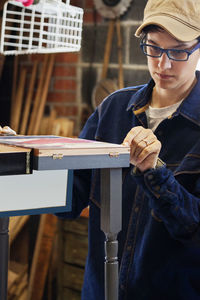 Female worker checking wood in workshop