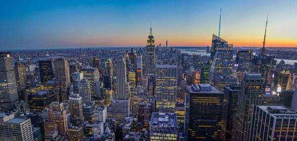 Aerial view of buildings in city at sunset