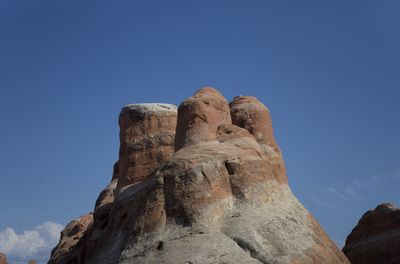 Low angle view of rock formations against blue sky