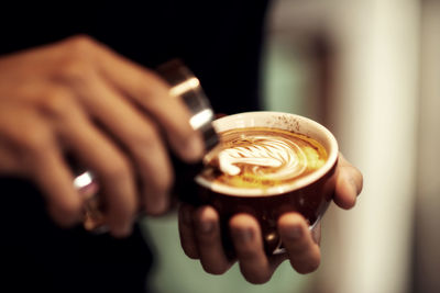 Cropped image of hand holding coffee cup