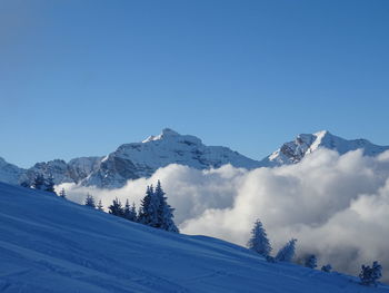 Scenic view of snowcapped mountains against clear blue sky