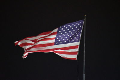 Low angle view of flag against black background