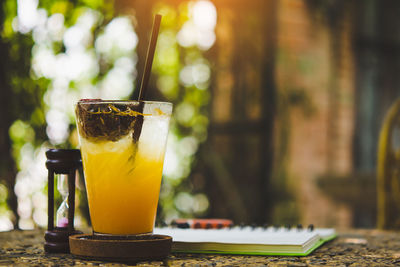 Fresh passion fruit juice in glass on table with is tree garden background