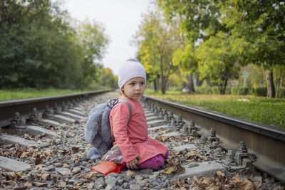 Boy sitting on railroad track