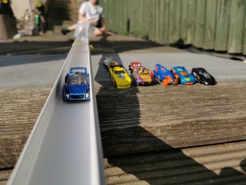Close-up of toy car on track with child behind 