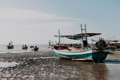 Sailboats moored on sea against sky