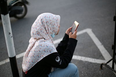 Rear view of woman using mobile phone