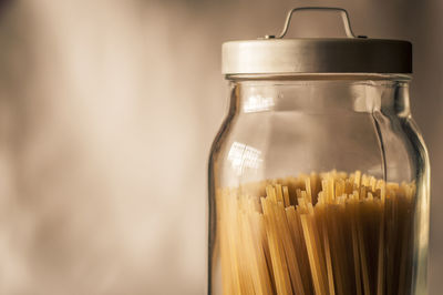 Spaghetti inside a transparent cristal jar with a gray metal cap