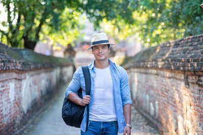 Portrait of young man wearing hat standing outdoors